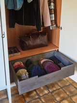 Tiroir en bois avec des écharpes et accessoires dans une armoire vestiaire sur mesure avec étagère pour sac de voyage