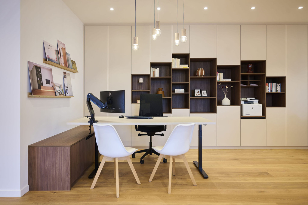 Espace de travail avec bureau et mur de placards sur mesure avec niches ouvertes et rangements en showroom