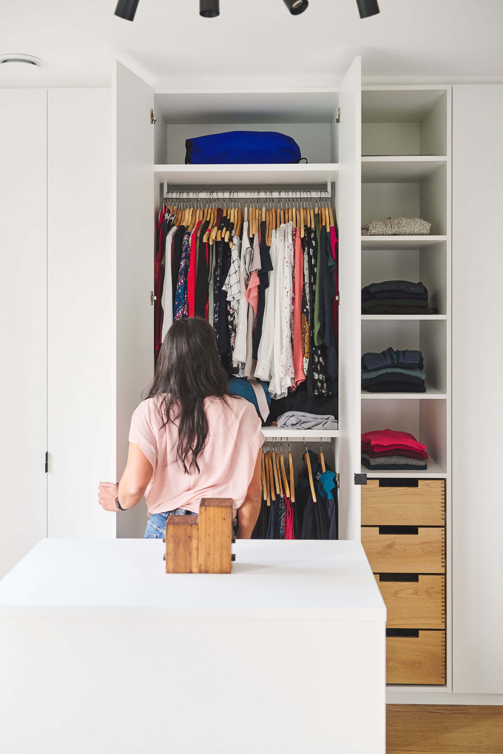 intérieur d'un dressing blanc sur mesure avec des étagères, des tiroirs et des penderies courtes