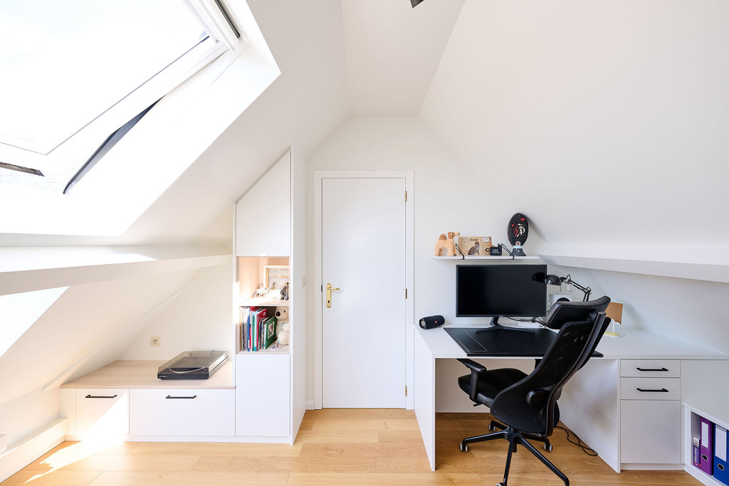 Bureau sur mesure avec placard intégré sous pente et espace de travail dans une chambre d’enfant