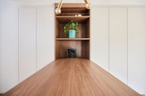 Détail d’une niche ouverte en décor bois avec étagères, intégrée dans une armoire sur mesure blanche avec plan de travail en bois