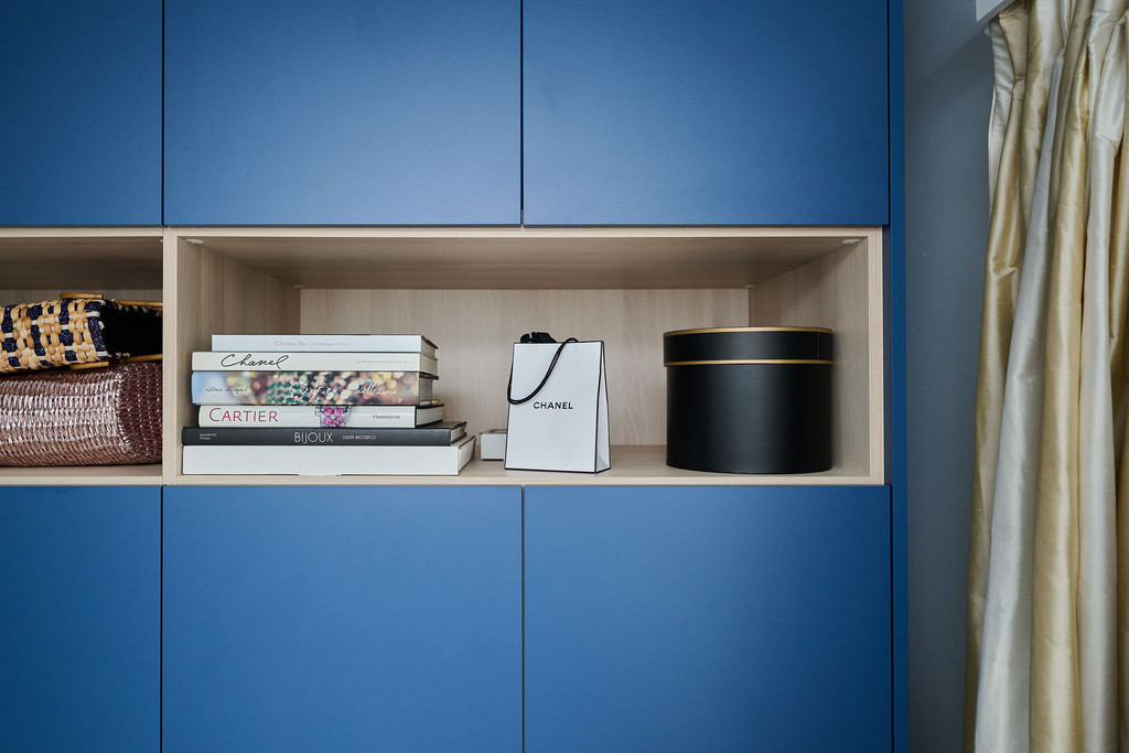 Dressing bleu avec niches ouvertes en teinte de bois avec décoration