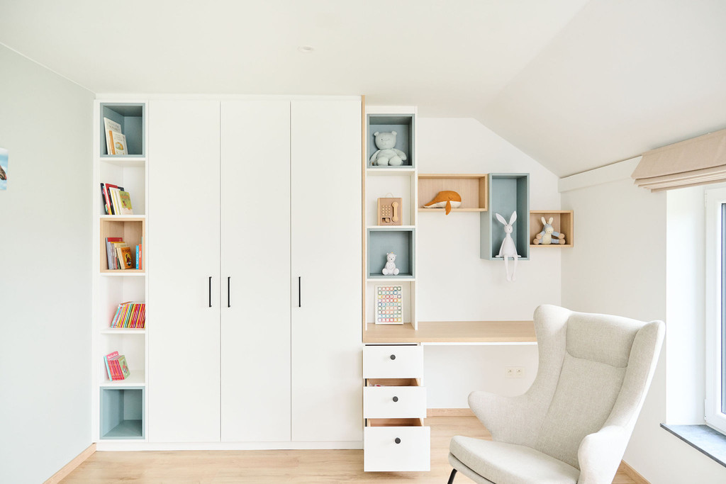 Chambre d'enfant sur mesure avec armoire blanche, étagères décoratives et bureau intégré.