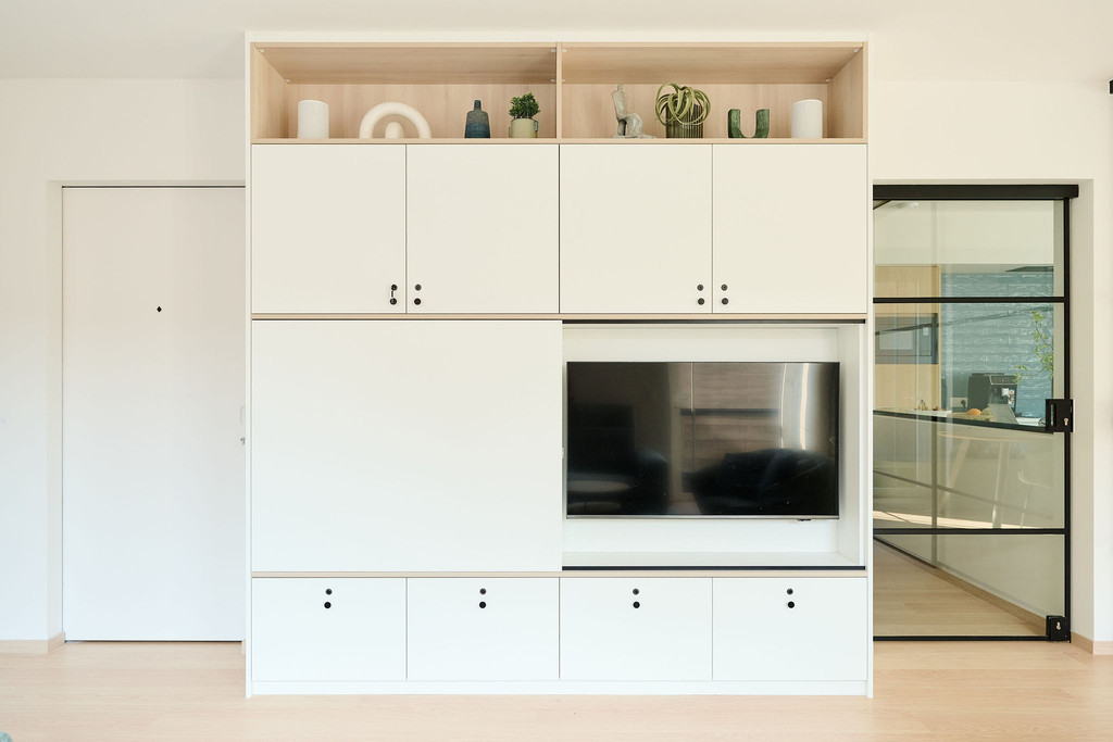 Grand meuble mural blanc avec TV intégrée et espaces de rangement fermés
