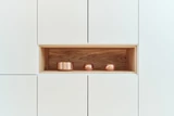 Op maat gemaakte kast met open houten nis en decoratieve accessoires.