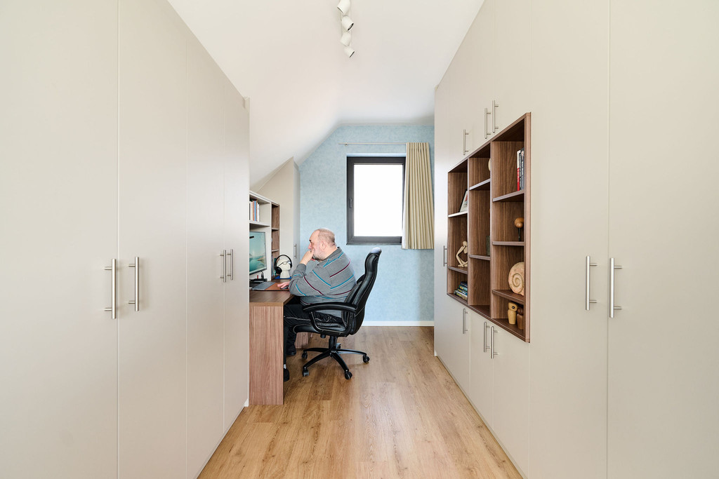 Bureau sur mesure intégré entre des armoires avec niches ouvertes en bois, optimisant un espace étroit pour créer un coin de travail fonctionnel, réalisé par Camber