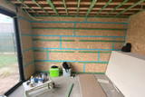 Espace intérieur brut avec murs en OSB et structure en bois visible en phase de chantier