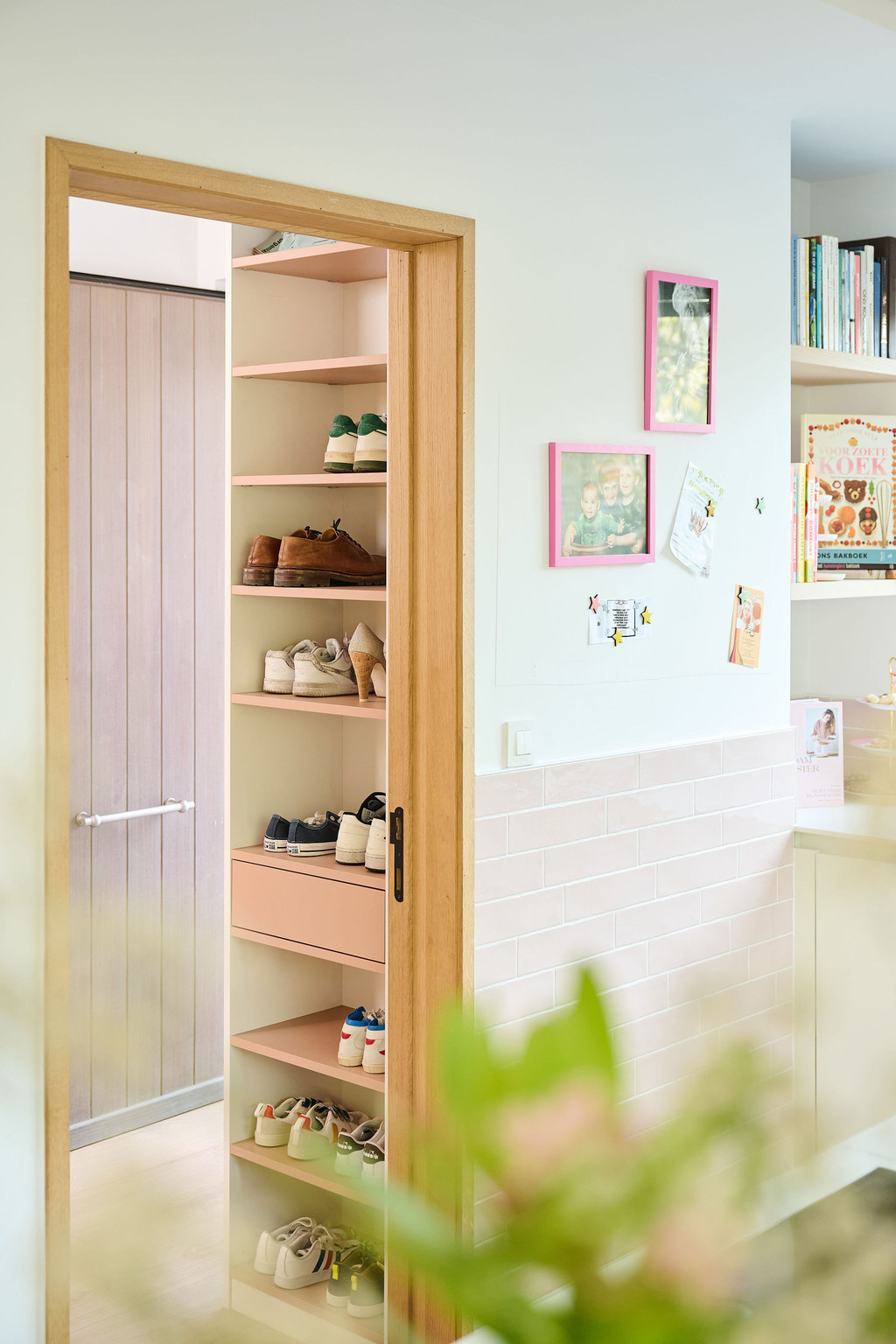 Détail d’une vestiaire Camber sur mesure avec colonne à étagères ouvertes pour chaussures et accessoires, intégrée dans un aménagement clair et fonctionnel à proximité de l’espace de vie