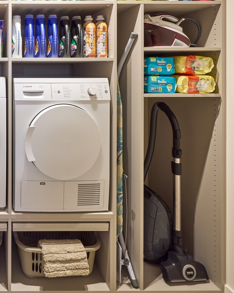 Open opbergkast met plaats voor wasmachine, stofzuiger en strijkplank