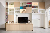 Meuble TV sur mesure blanc et bois clair avec niches ouvertes et fermées et accessoires décoratifs