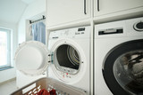 Wasmeubel op maat met ingebouwde wasmachine en droger, inclusief opbergruimte voor wasaccessoires.
