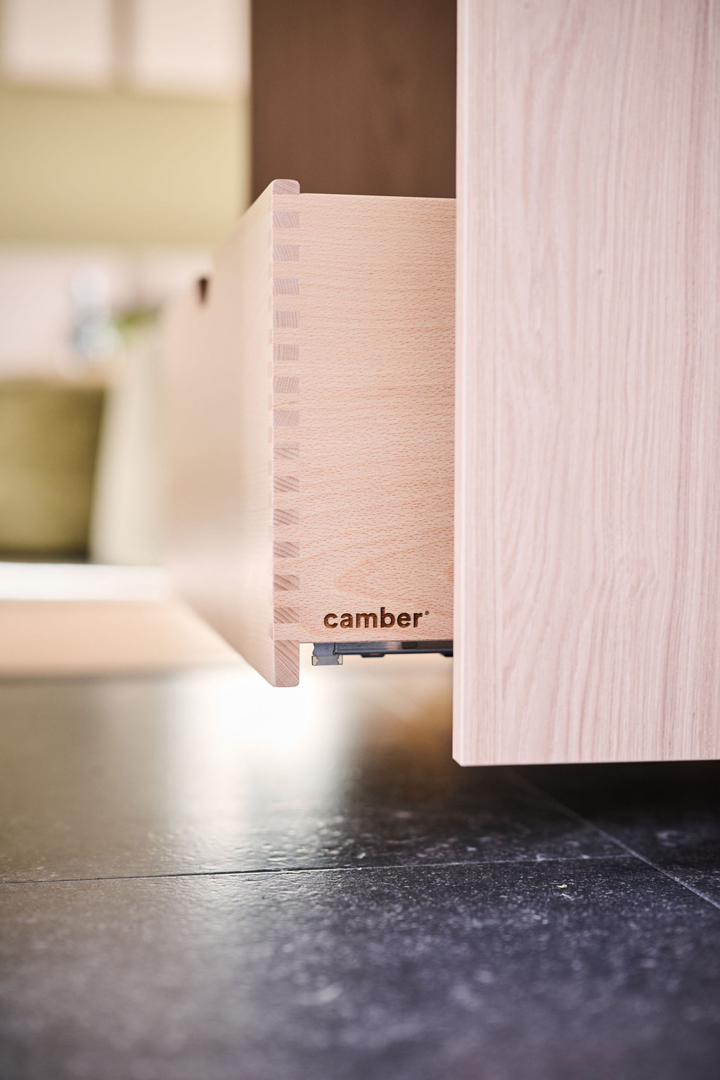 Close-up van een houten lade op zwarte vloer, met zichtbare zwaluwstaartverbinding