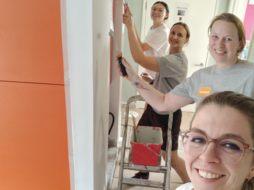 L’équipe RH de Camber repeint les murs d’un centre de jeunes lors d’une action solidaire.