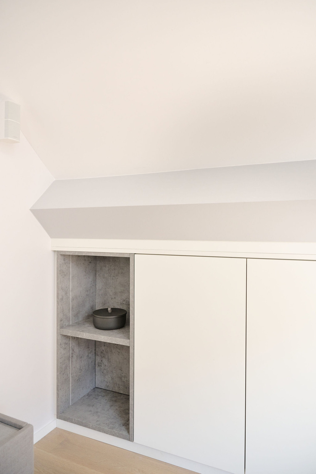 Meuble blanc fermé sous pente avec niches ouvertes