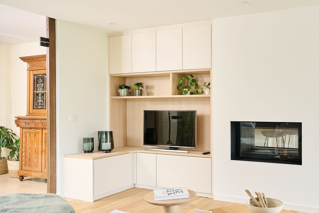 Hoek-tv-meubel op maat met open vakken met decoratie en geopende bovenkasten