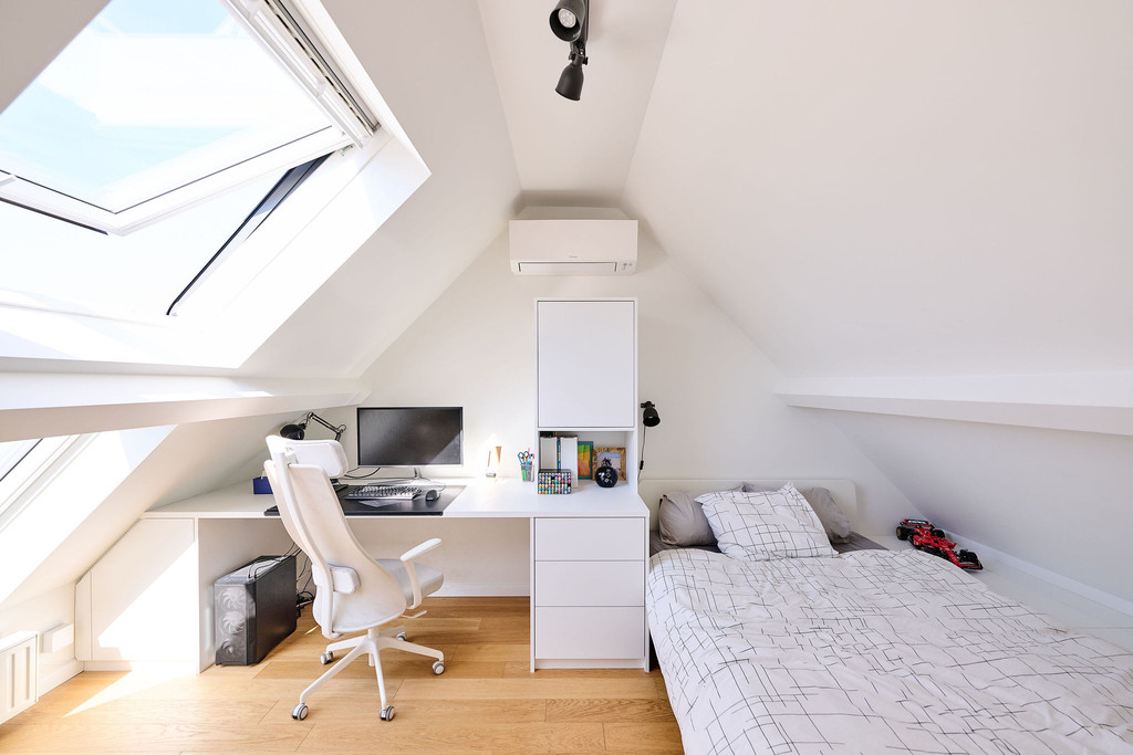 Bureau sur mesure avec rangements et lit sous pente dans une chambre d’enfant lumineuse