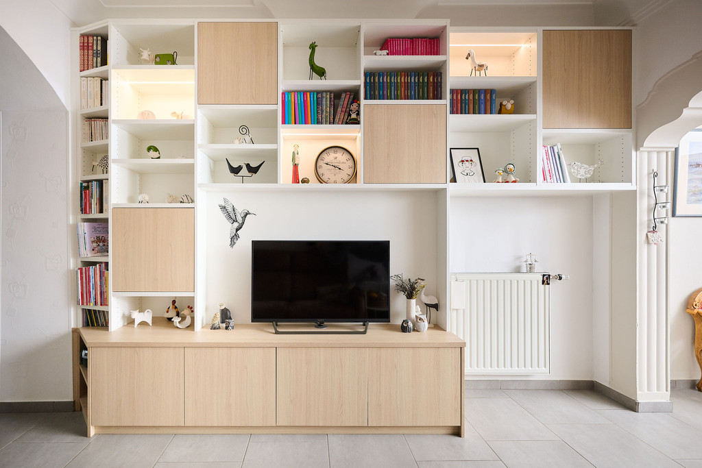 Wit en houtkleurig op maat gemaakt tv-meubel met open en gesloten vakken en decoratieve accessoires