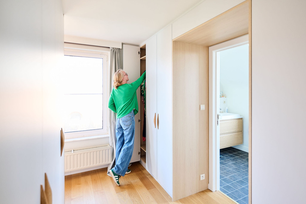 Placard sur mesure autour d’une ouverture avec penderie et rangements dans une chambre lumineuse