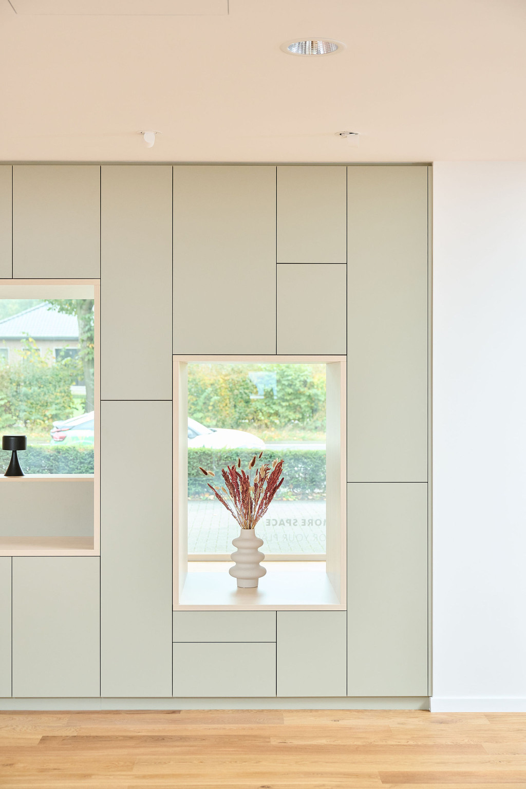 Kast op maat salon in saliegroen met open gedeelte in lichte houttint