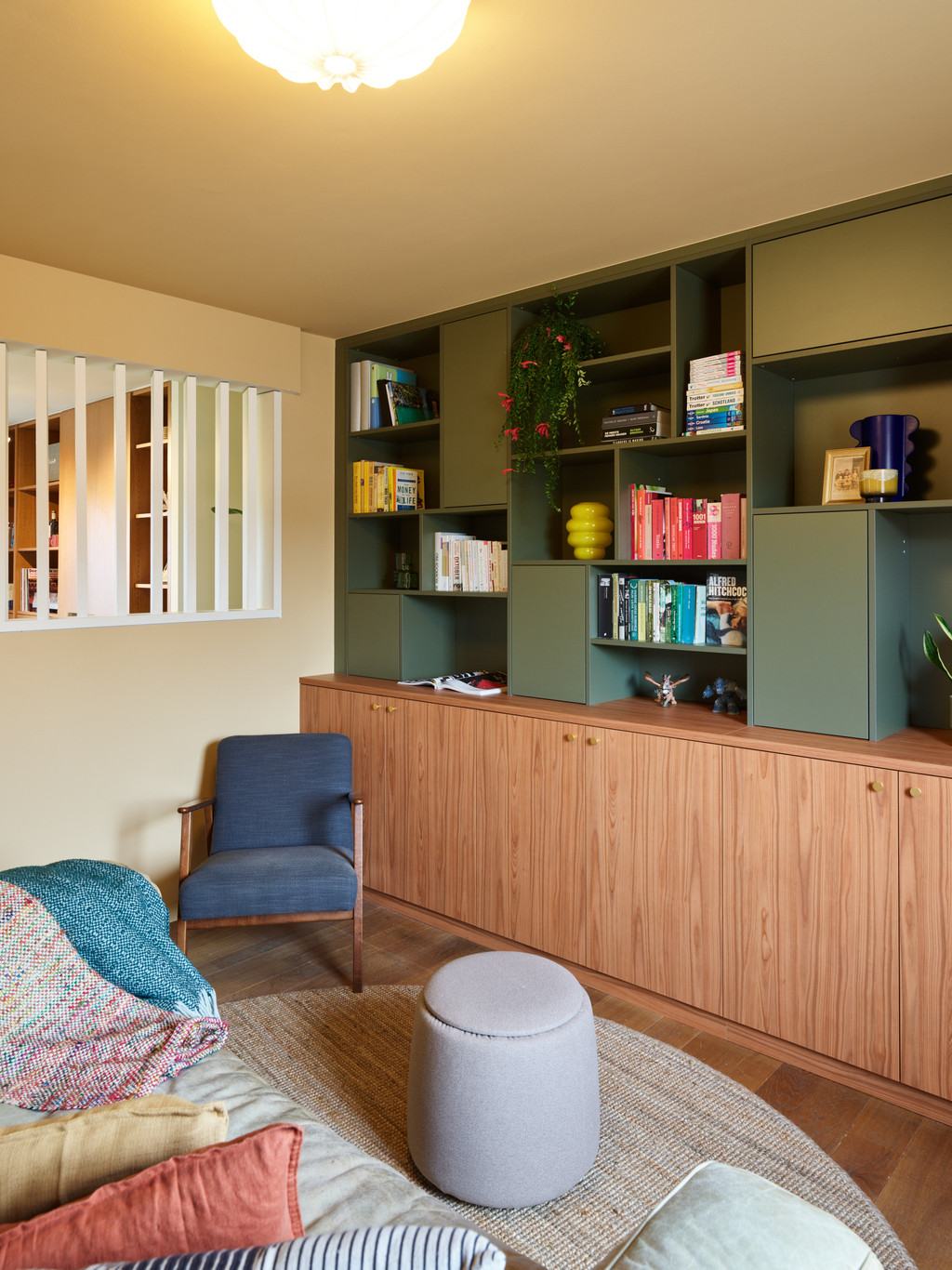 Meuble mural sur mesure en vert olive et bois avec livres et objets déco