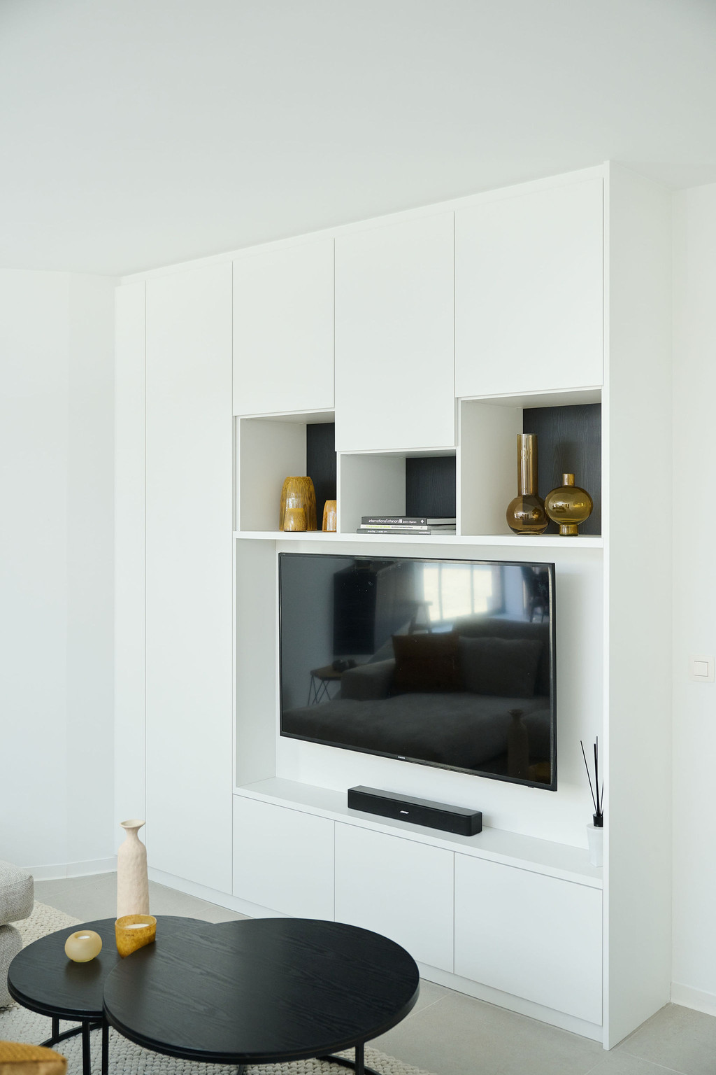 Witte tv kast op maat in living met open en gesloten compartimenten