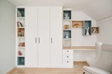 Chambre d'enfant sur mesure avec bibliothèque, rangement, et coin bureau intégré, décoré de jouets.