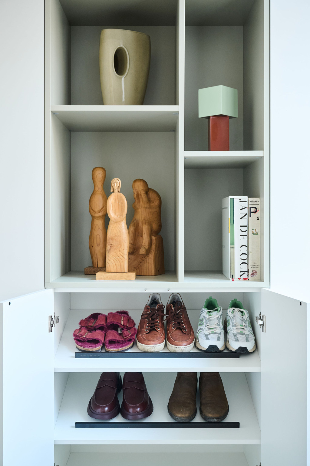 Armoire blanche ouverte sur mesure avec niches décoratives et rangement pour baskets dans le bas