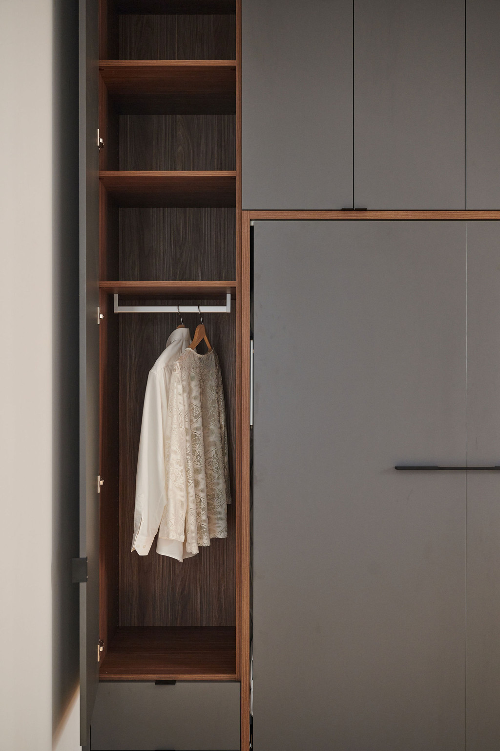 Opklapbed op maat met geïntegreerde kast en hanggedeelte voor kleding in een moderne slaapkamer
