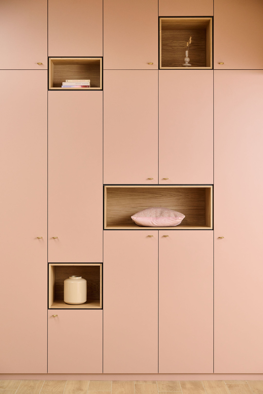 Mobilier de rangement sur mesure avec niches décoratives, mettant en valeur des objets minimalistes et modernes.