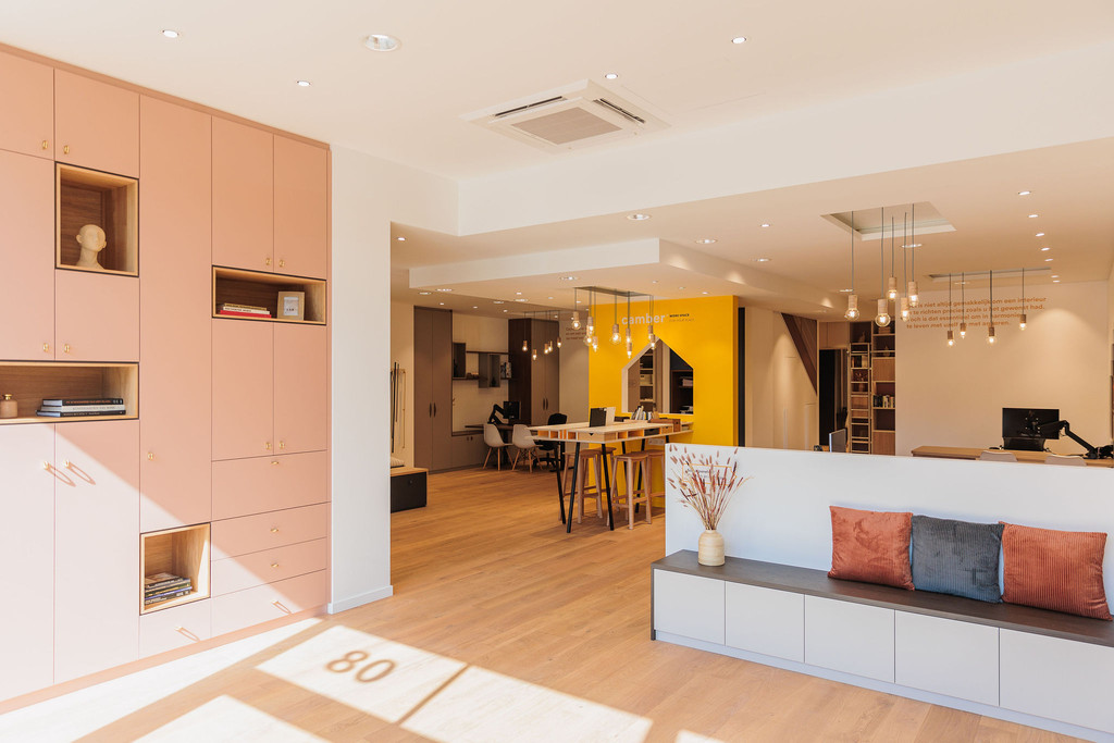 Interieur van de showroom in Hasselt met boekenkast op maat en vestiairemeubel