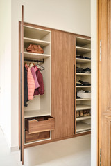 Vestiaire fermé sur mesure avec étagères, tringle à vêtements et tiroir, offrant un rangement pratique et organisé pour l'entrée.