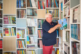 Guido neemt een boek uit een wandvullende bibliotheekkast op maat met open vakken en gesloten opbergvakken
