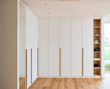 Witte gesloten dressing in L-vorm op maat met houten open nissen