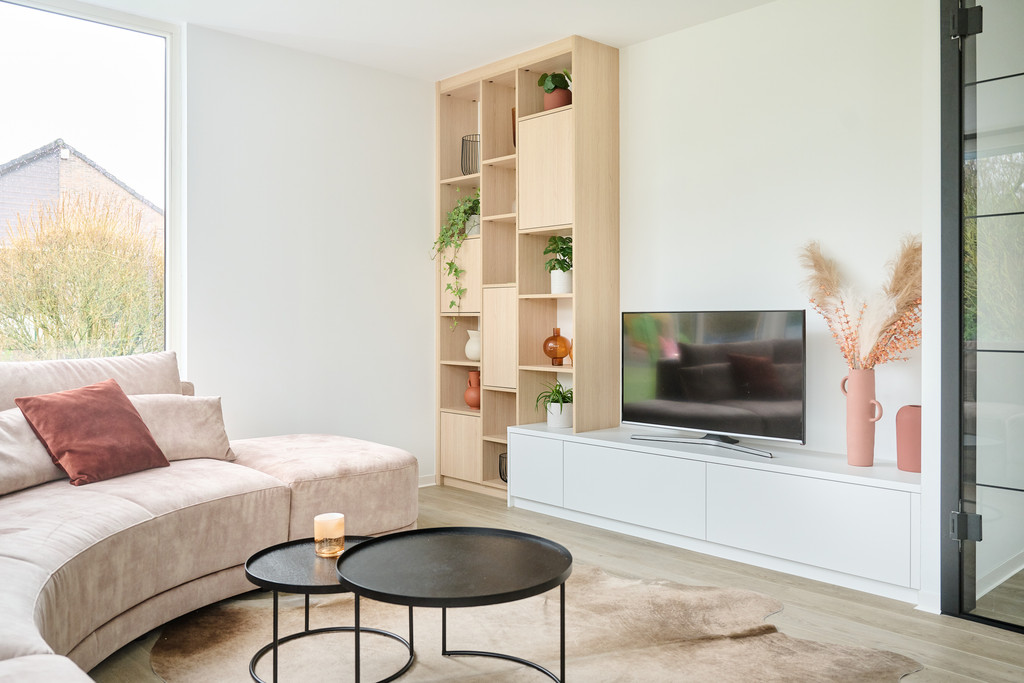 witte ingebouwde tv kast met hoge houten kast langs de muur