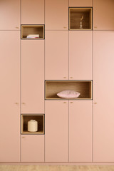 Mobilier de rangement sur mesure avec niches décoratives, mettant en valeur des objets minimalistes et modernes.