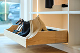 Tiroir à chaussures en bois sur mesure avec des compartiments pour ranger des bottines et des chaussures.