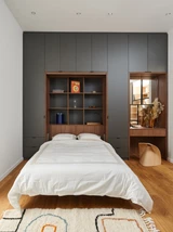 Chambre moderne avec meuble sur mesure intégrant une niche bibliothèque, style minimaliste avec des éléments décoratifs.