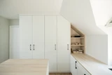 Dressing sous pente avec rangements intégrés et étagères ouvertes, offrant un espace fonctionnel et esthétique.