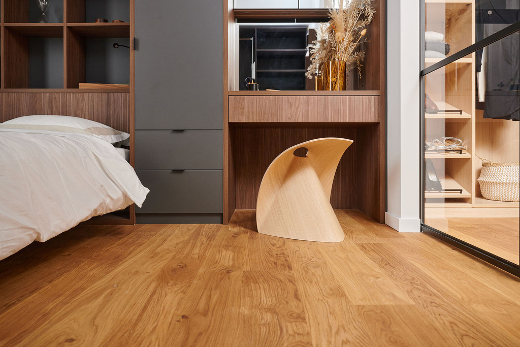 Chambre à coucher avec coiffeuse intégrée sur mesure en bois foncé et chaise design en bois clair