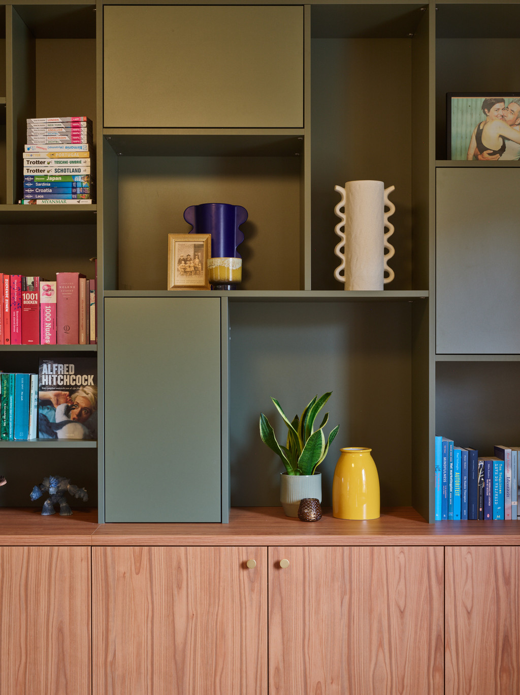 Meuble mural ouvert avec livres, accessoires et vase jaune
