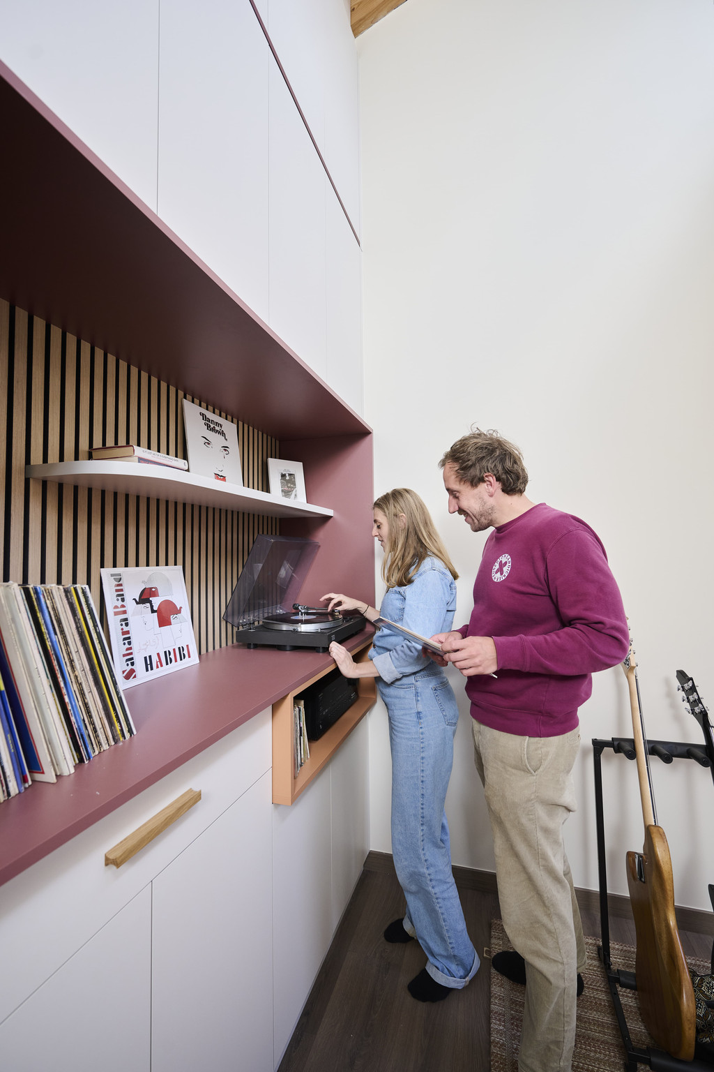 Couple devant un meuble mural sur mesure avec niches et tourne-disque dans un espace de vie moderne