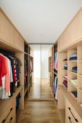 Dressing sur mesure en forme de U avec étagères ouvertes et penderie pour un rangement optimal.