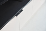 Deur met minimalistische greep in wit en zwart op maat gemaakte meubel.