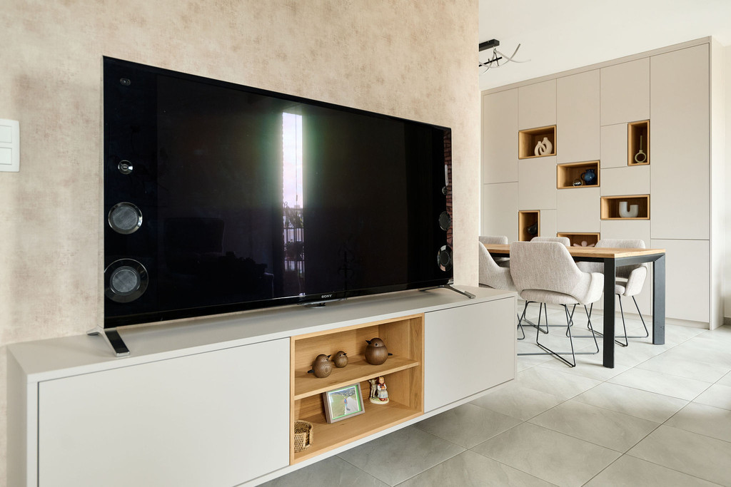 Meuble TV sur mesure avec niche ouverte en finition bois et rangements fermés, apportant chaleur et fonctionnalité dans un intérieur moderne, réalisé par Camber