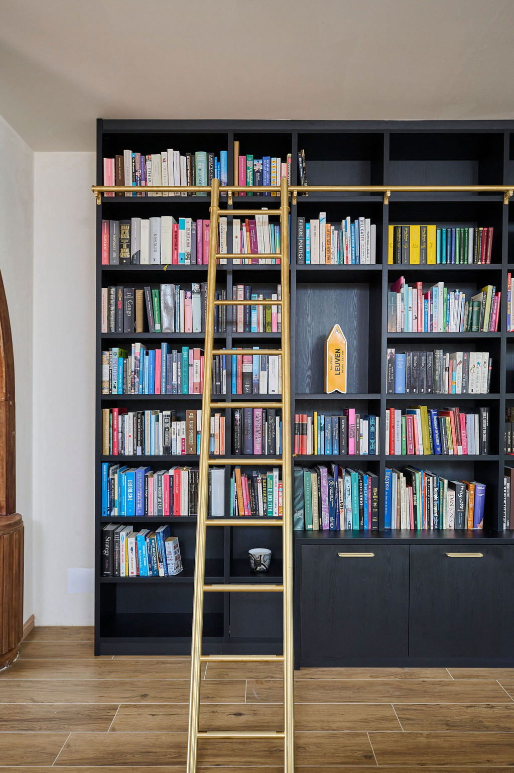 Boekenkast op maat met open nissen en gouden ladder