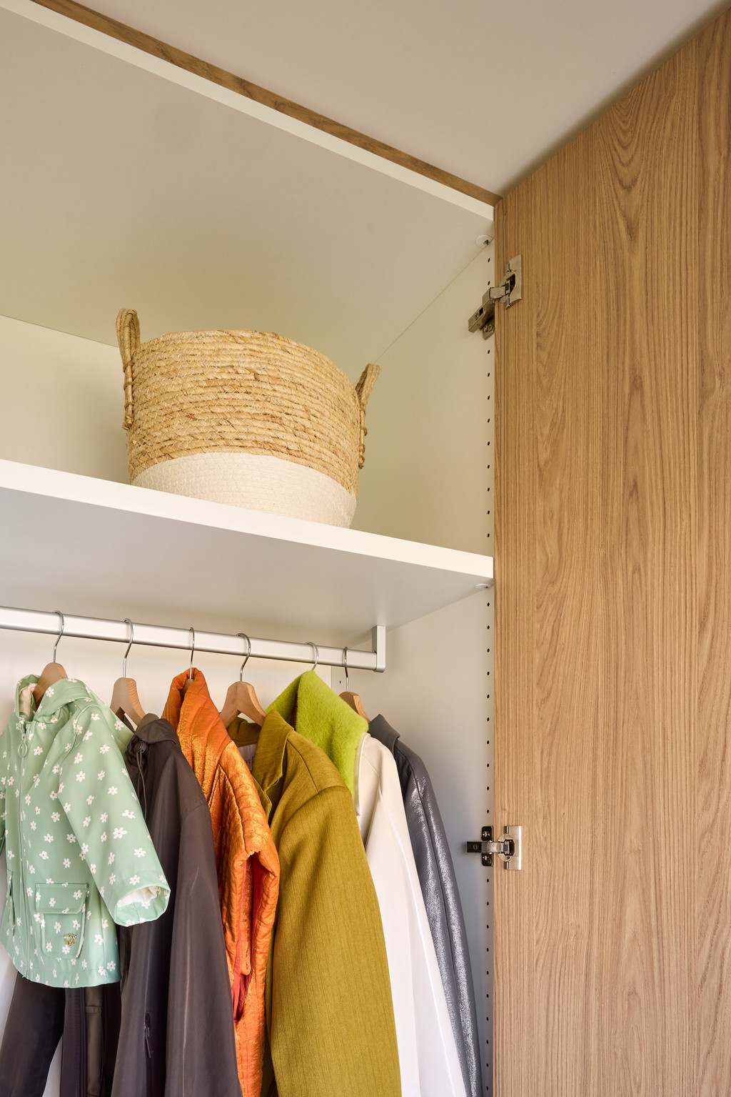 Detail van een vestiairekast op maat met hangruimte, bovenste legplank en houtafwerking, voor een praktische en elegante inkomhal