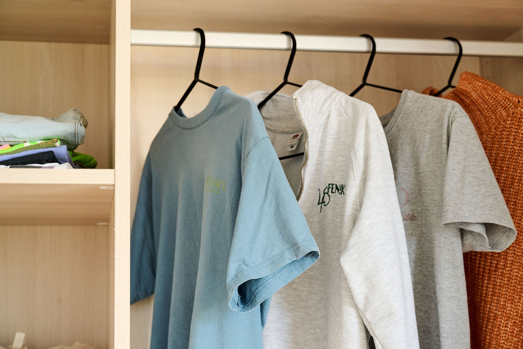 Détail d’un dressing sur mesure avec tringle à vêtements et étagères en bois