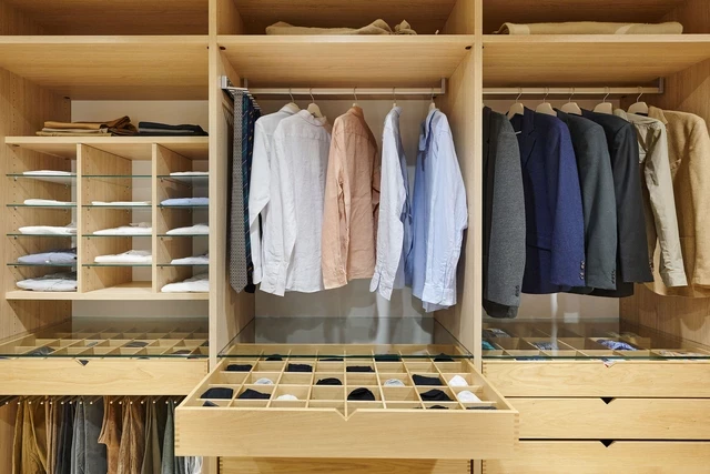 Kledingkast op maat in U-vorm met hangruimte voor kleding, lades voor accessoires en opbergvakken voor georganiseerd gebruik.
