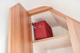 Op maat gemaakte kast onder schuine wand met opbergvak voor een rode doos.