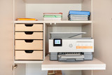 Op maat gemaakt bureau met geïntegreerde opbergkast, houten lades en een uitschuifbaar plateau voor een printer.